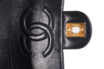 Lot 17 - A Chanel quilted navy leather bag, 1990s,...